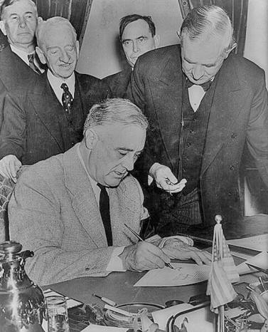 President Roosevelt signs the declaration of war against the Japanese Empire